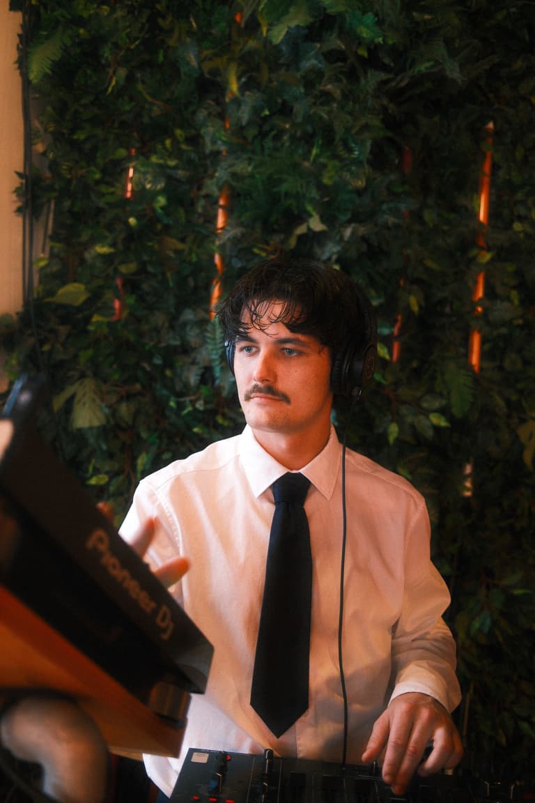 Jayden working the decks in a white shirt and tie